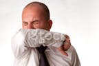 Male Sneezing Into Arm