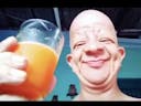 bald guy drinking orange juice